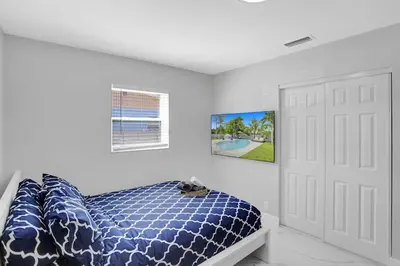 a bedroom with a blue and white bed and a door at Yehudas Tropical Villa with Heated Infinity Pool in Hollywood