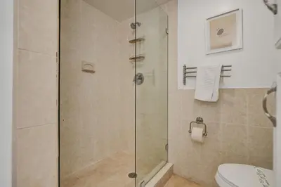 a bathroom with a glass shower with a toilet at Cozy Beachfront 2 BDR Miami Beach Condo 1114 in Miami Beach