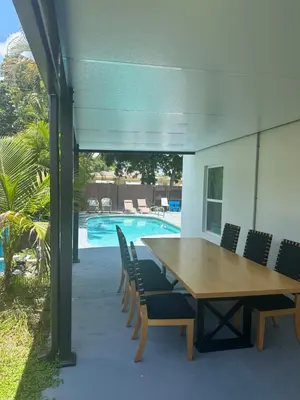 a wooden table and chairs next to a pool at Pool house 3 bedroom 2 bathroom in North Miami Beach