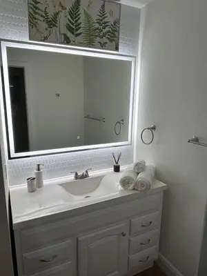 a bathroom with a sink and a large mirror at Westchester Garden in Miami