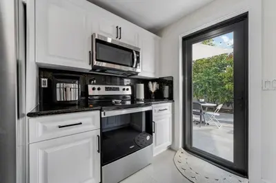 a kitchen with a stove and a microwave at Westchester Garden in Miami