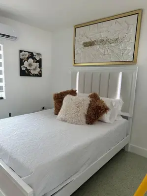 a white bed with two stuffed animals on it at Villa Clara Gold-Little Havana in Miami