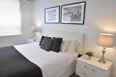 a bedroom with a white bed with two night stands and two lamps at 515-Trendy 2Bd2Ba Midtown HUGE private patio! in Miami