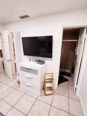 a living room with a television and a tiled floor at Amazing 5 Bedroom Pool Home - Minimum 28 days Stay Only Great Location! in Miramar