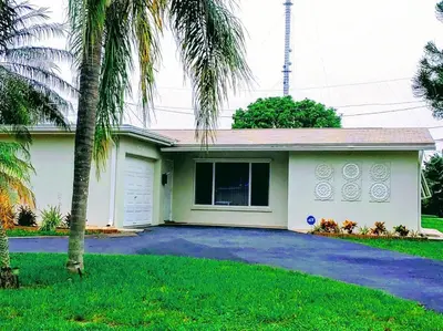 a house with palm trees in front of it at Amazing 5 Bedroom Pool Home - Minimum 28 days Stay Only Great Location! in Miramar