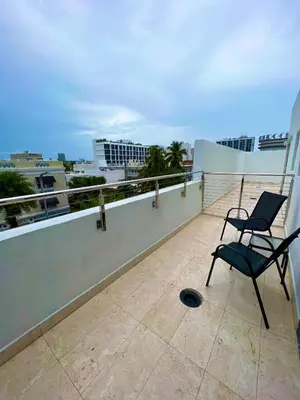 a chair sitting on top of a balcony at Seaside Serenity Duplex in Miami Beach