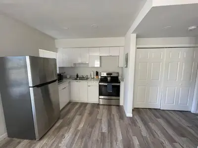 a kitchen with white cabinets and a stainless steel refrigerator at Fully equipped Apartments with parking near Cocowalk in Miami