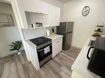 a small kitchen with a stove and a refrigerator at Fully equipped Apartments with parking near Cocowalk in Miami
