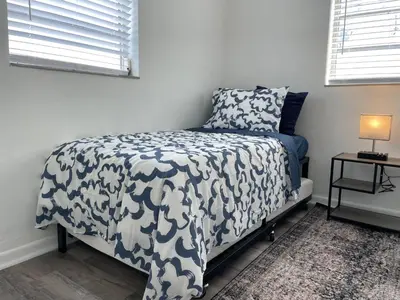 a bedroom with a bed with a black and white blanket at Remodeled Little Havanna Apartments great location in Miami