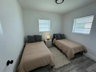 two beds in a white room with two windows at Remodeled Little Havanna Apartments great location in Miami