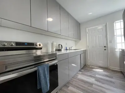 a kitchen with stainless steel appliances and white cabinets at Remodeled Little Havanna Apartments great location in Miami