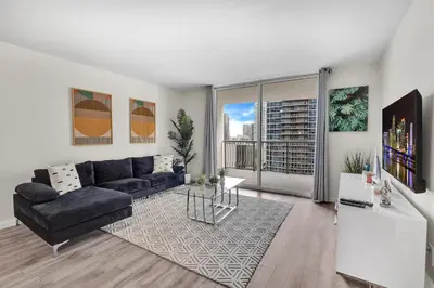 a living room with a couch and a large window at Brickell Key Gem: Stylish 1-Bed W/ Free Parking in Miami