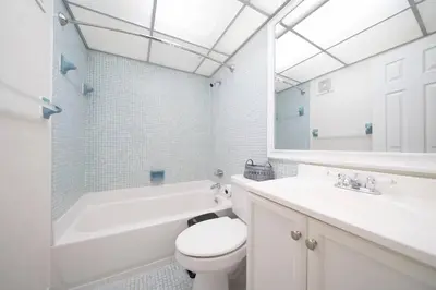 a white bathroom with a toilet and a tub and a sink at Enjoy Fully Equipped 2BR Condo Near The Beach in Sunny Isles Beach