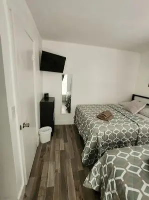 a bedroom with two beds and a wooden floor at Walk to Hard Rock ~ Amazing 5 Star Home Away From Home! in Miami Gardens