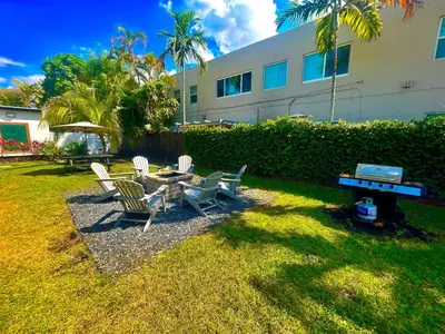 a backyard with a table and chairs and a grill at MiamiVice Las Olas Near Beach and Park w Fire Pit in Fort Lauderdale