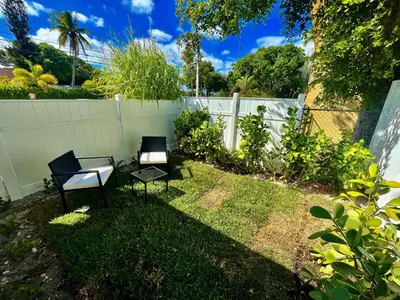 two chairs sitting in a yard next to a fence at MiamiVice Las Olas Near Beach and Park w Fire Pit in Fort Lauderdale