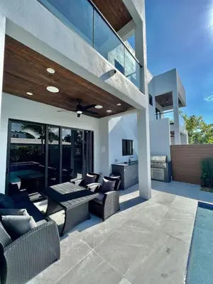 a patio with couches and a television on a house at Elements Las Olas w Pool and Spa Near Beach in Fort Lauderdale