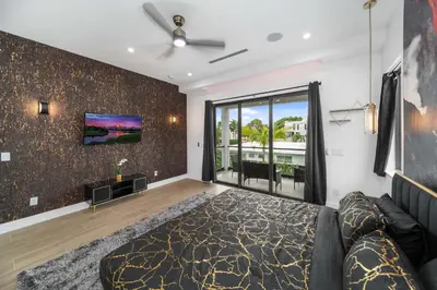 a bedroom with a bed and a tv on a wall at Elements Las Olas w Pool and Spa Near Beach in Fort Lauderdale