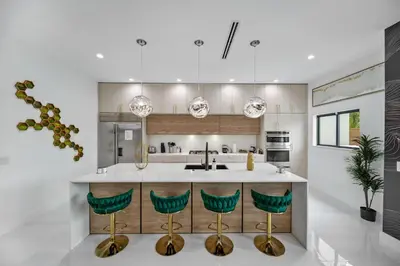 a kitchen with a island with green bar stools at Elements Las Olas w Pool and Spa Near Beach in Fort Lauderdale
