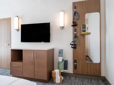 a room with a tv and a mirror at EVEN Hotel Miami - Doral Area by IHG in Sweetwater