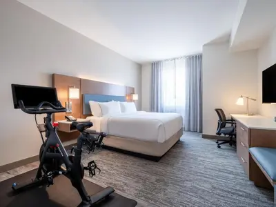 a hotel room with a bed and a treadmill at EVEN Hotel Miami - Doral Area by IHG in Sweetwater