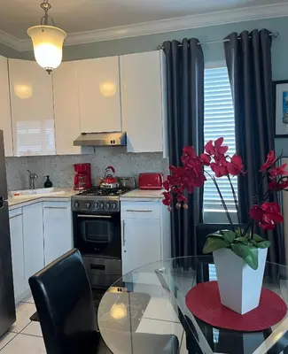 a kitchen with a glass table and a kitchen with a stove at Ocean Breeze Studio With Parking By The Beach in Miami Beach