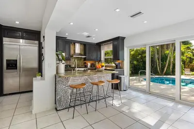 a kitchen with a island with bar stools and a pool at The Wellness Retreat- Amazing Amenities Near Beach in Hollywood