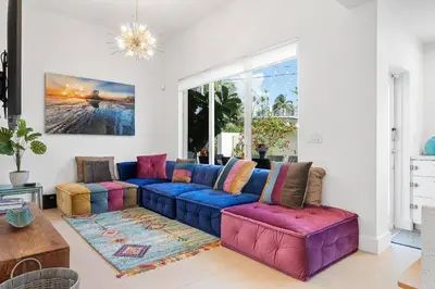 a living room with a blue couch and colorful chairs at Sea La Vie FL in Fort Lauderdale
