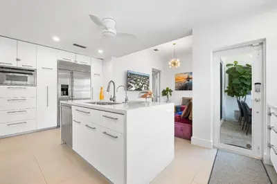 a kitchen with white cabinets and a kitchen island at Sea La Vie FL in Fort Lauderdale