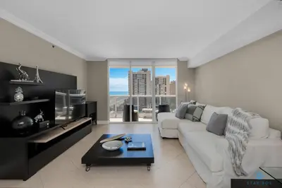 a living room with a white couch and a large window at Amazing View Beachfront Resort Luxury Amenities in Hallandale Beach