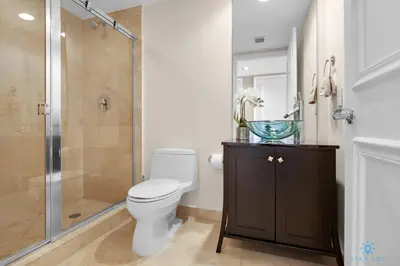 a bathroom with a toilet and a glass shower at Amazing View Beachfront Resort Luxury Amenities in Hallandale Beach
