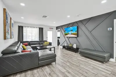 a living room with a leather couch and a tv at Seaside Oasis in Hollywood Lakes near the Beach in Hollywood