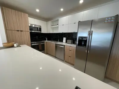 a large kitchen with a stainless steel refrigerator at Stunning apt! Oceanview! Parking included in Sunny Isles Beach