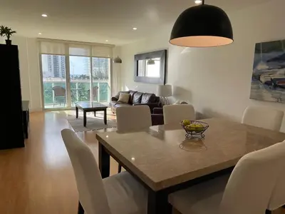 a living room with a table and chairs and a couch at Stunning apt! Oceanview! Parking included in Sunny Isles Beach