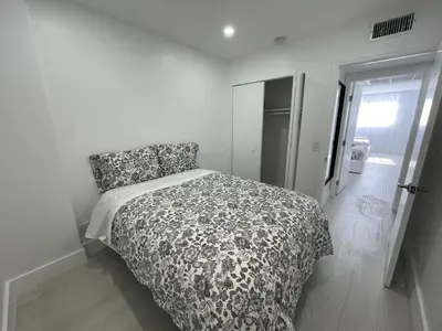 a bedroom with a bed with a black and white comforter at Amazing Ocean View! 10 floor Parking included in Sunny Isles Beach