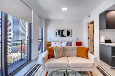 a living room with a couch and a large window at Ocean View Designer Studio, Pool in Miami