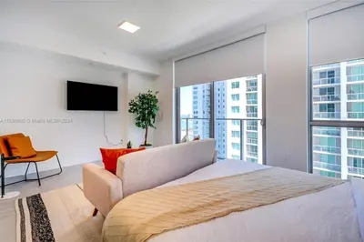 a bedroom with a large bed and a tv at Ocean View Designer Studio, Pool in Miami