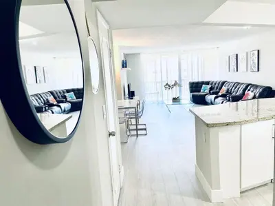 a living room with a mirror and a couch at MODERN 2BR 2BA CONDO near AVENTURA! Wi-Fi! Parking in North Miami Beach