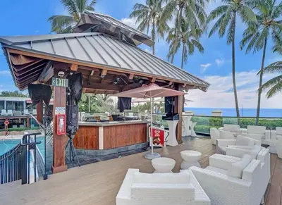 a bar with white furniture next to a pool at AK414- Miami Beach Apt at Oceanfront Resort in Miami Beach