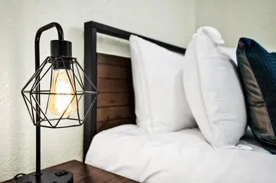a lamp on a table next to a bed with white pillows at Hollywood Villa Luxury & Private Pool in Hollywood