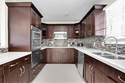 a kitchen with wooden cabinets and stainless steel appliances at Hollywood Villa Luxury & Private Pool in Hollywood