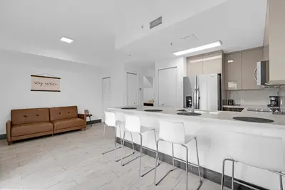 a kitchen with a bar with chairs and a couch at Biscayne Park Villas 15400 in Miami