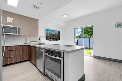 a kitchen with stainless steel appliances and a large window at Biscayne Park Villas 15400 in Miami
