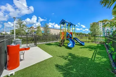 a playground with a slide in a park at 1 Mi to Hard Rock Stadium! Chic Retreat with Pool in Joe Robbie Stadium Heliport