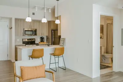a kitchen with a counter and two chairs in a room at Hard Rock Stadium Home Base! Luxe Condo with Pool in Joe Robbie Stadium Heliport