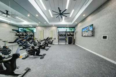 a gym with rows of treadmills and exercise bikes at Hard Rock Stadium Home Base! Luxe Condo with Pool in Joe Robbie Stadium Heliport