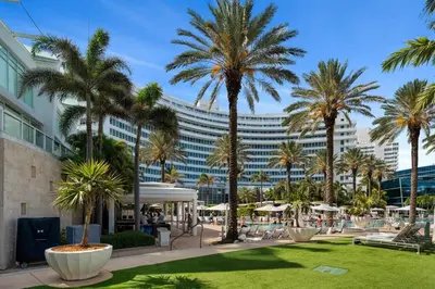 a park with palm trees and a large building at FontaineBleau Resort, with Balcony 10 min from SoBe in Miami Beach