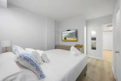 a white bedroom with a large bed with white pillows at Beautiful holiday apartment in Ocean Recerve near beach in Sunny Isles Beach