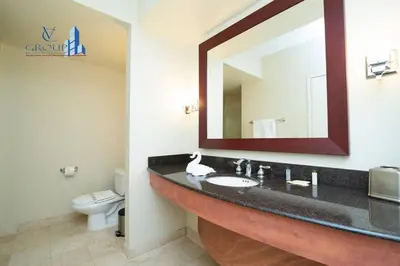a bathroom with a sink and a mirror and a toilet at Luxurious beachfront studio in Sunny Isles Beach