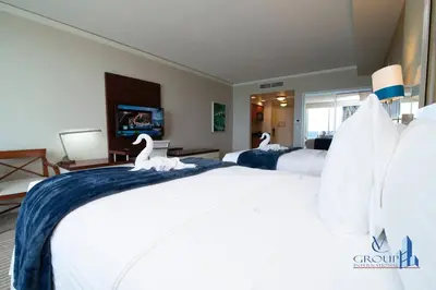 two beds in a hotel room with two swans on the bed at Luxurious beachfront studio in Sunny Isles Beach